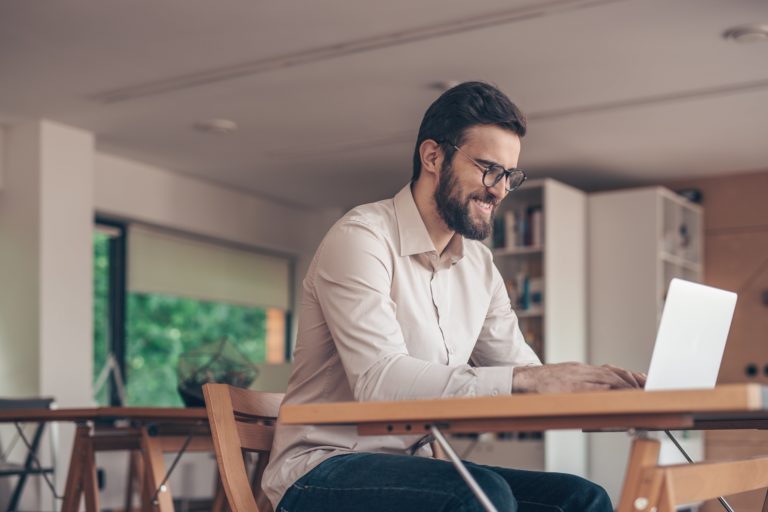 smiling-businessman-with-laptop-2BNSVH8-min